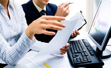 This is a picture of people discussing with a sheaf of papers in their hands.